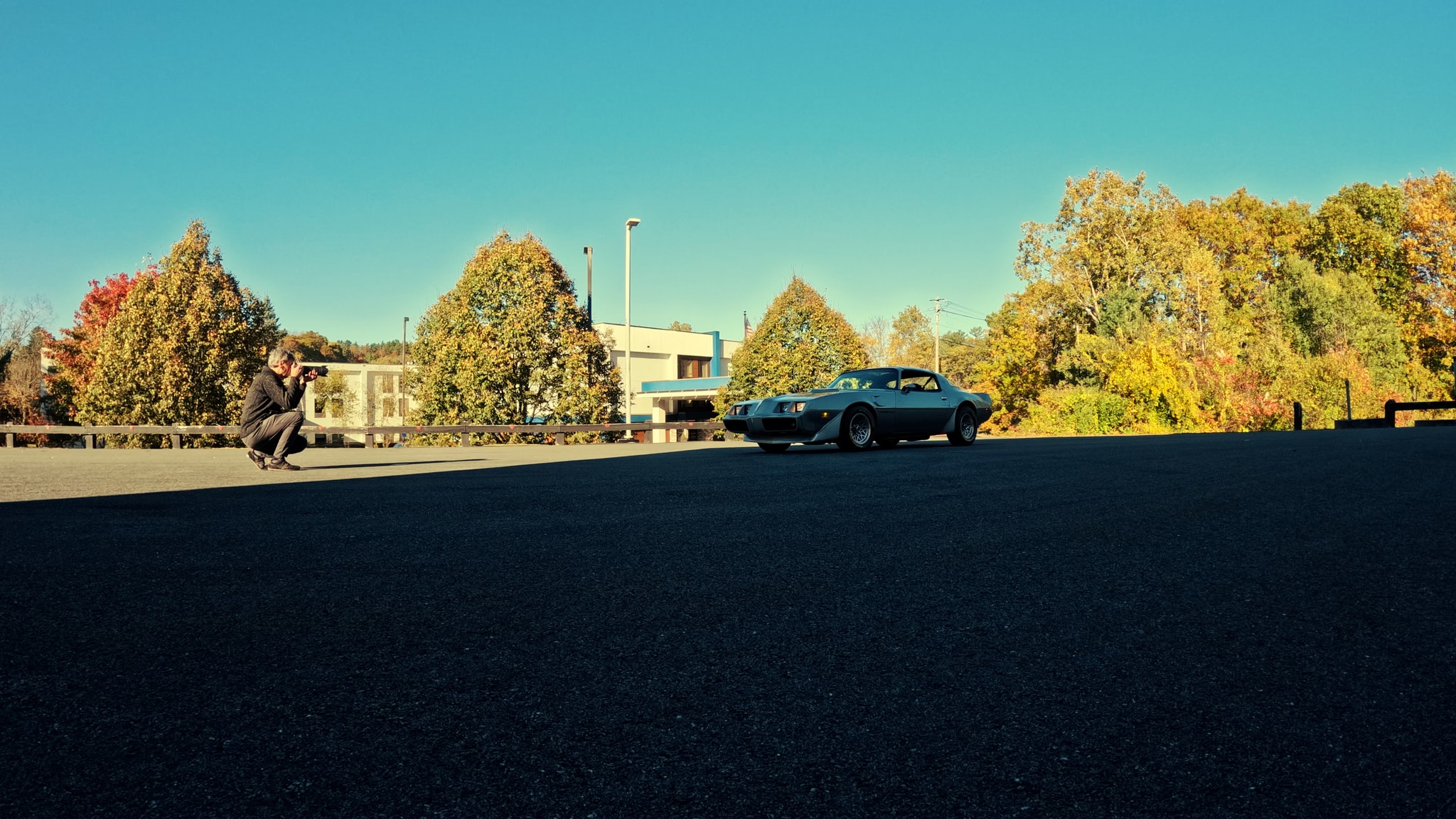 ViardPhotography — photographer crouched and shooting a 1979 Pontiac Firebird Trans Am in New England fall foliage